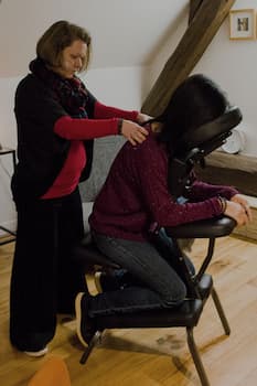 Massothérapeute réalisant un massage des 5 continents sur le bas du dos pour favoriser une détente profonde