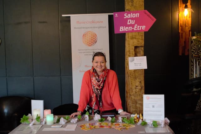Praticien bien‑être sur son stand au salon Les Sens en Éveil à la Ferme du Manet à Montigny‑le‑Bretonneux – massages assis EAS® et soins à Saint‑Quentin‑en‑Yvelines